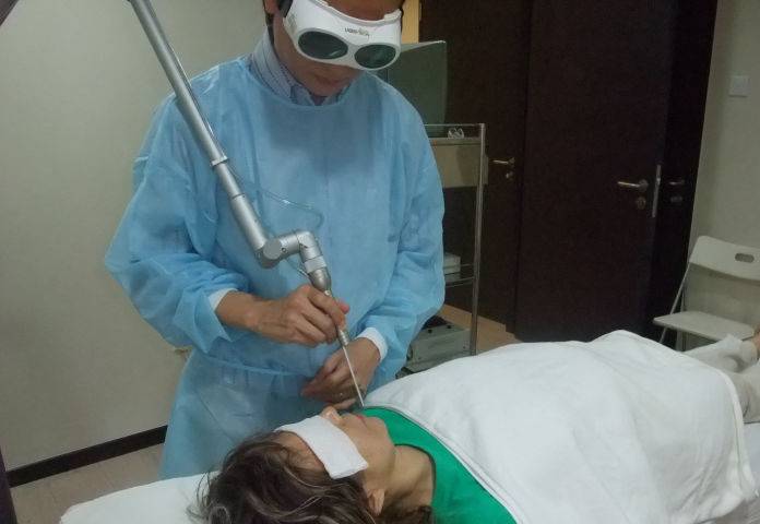 Roland Sim Song Teck doing laser in Facial Plastic Surgery clinic