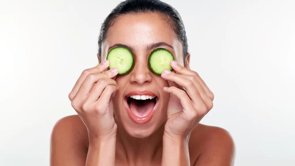 Image of woman putting cucumbers on her eyes