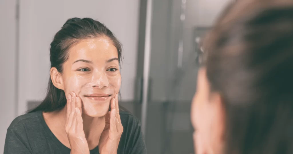 Woman applying skincare on face